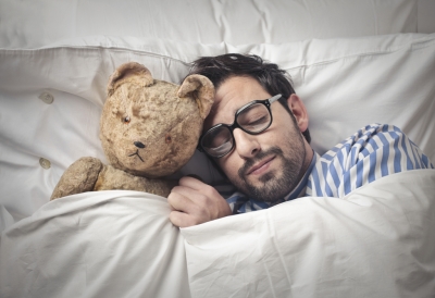 man sleeping with a teddy bear
